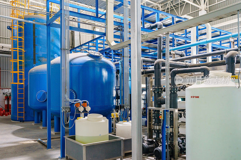 大型工业水处理及锅炉房。闪亮的钢铁管道，蓝色的泵和阀门。