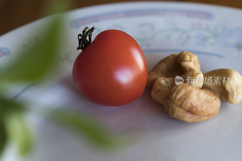 可爱的小红番茄旁边放着腰果。