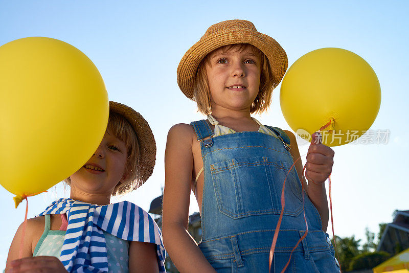 微笑的姐妹和明亮的气球
