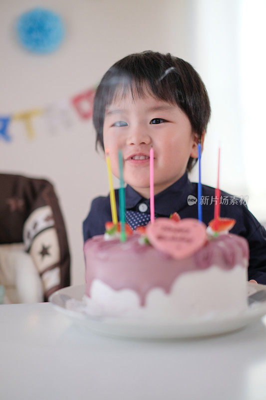 孩子吹灭生日蛋糕上的蜡烛，许他的愿望