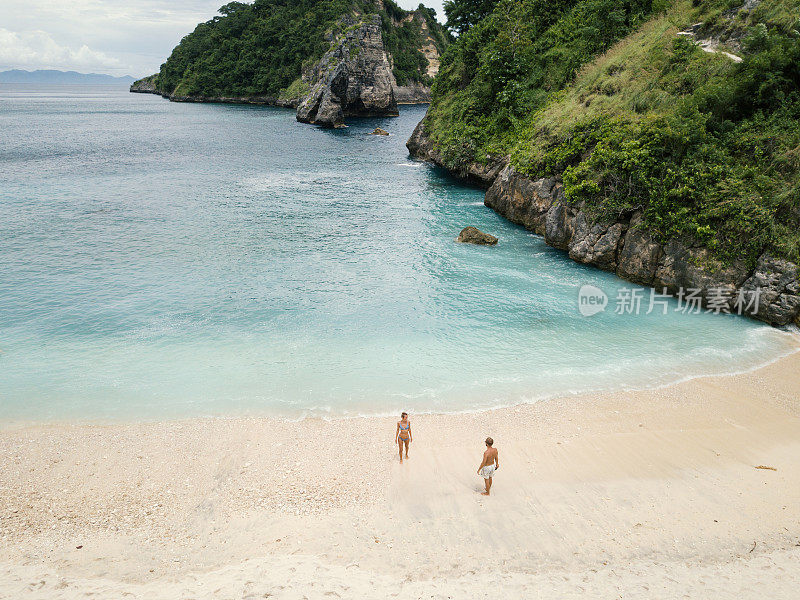 鸟瞰热带海滩上的年轻情侣享受度假和大自然，人们旅游探险的理念