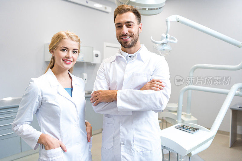年轻的男女牙医在牙科诊所看相机