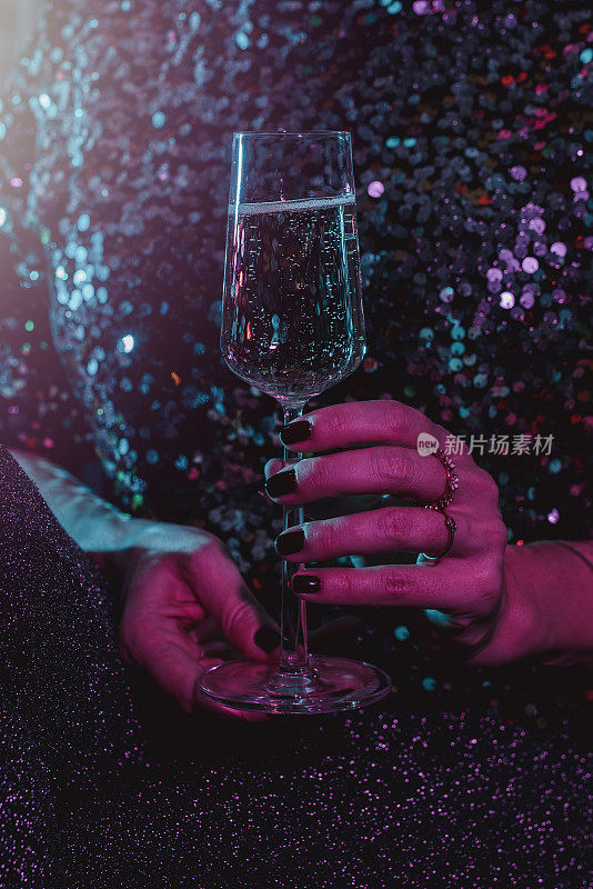 女人在新年派对上喝香槟起泡酒的特写