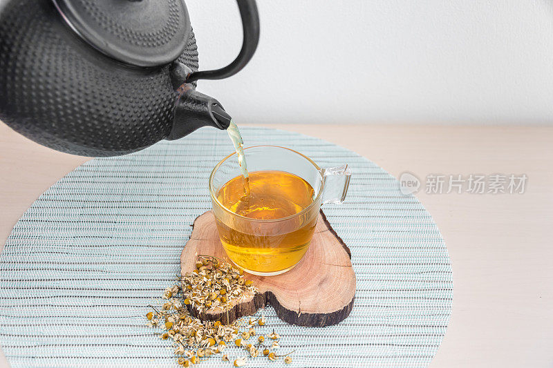 从茶壶中倒出甘菊茶