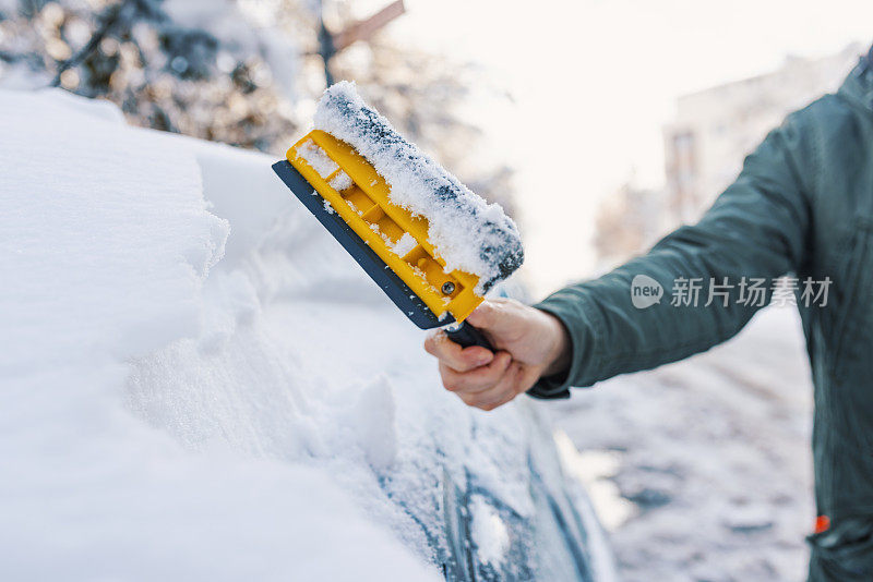 一个男人从他的车里清除雪