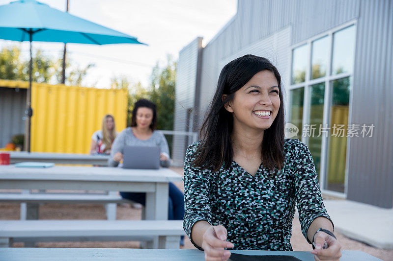 亚洲女企业家微笑着在现代的共同工作空间户外工作
