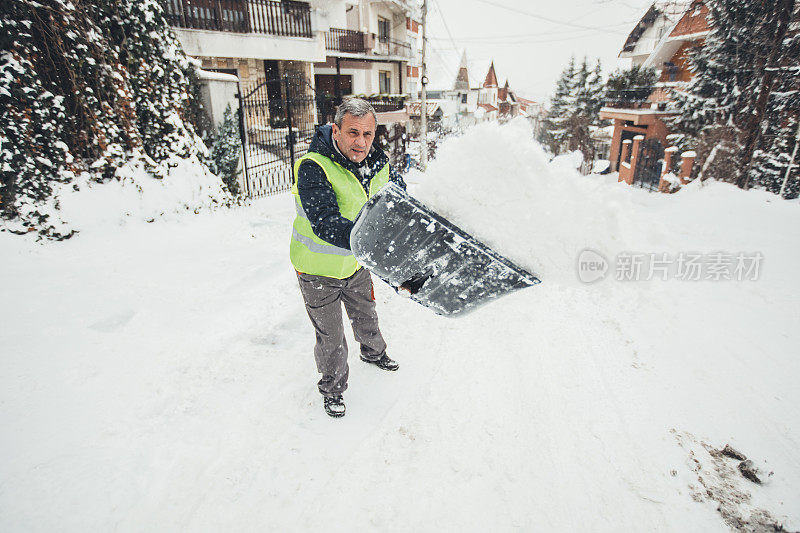 男人用雪铲清理雪