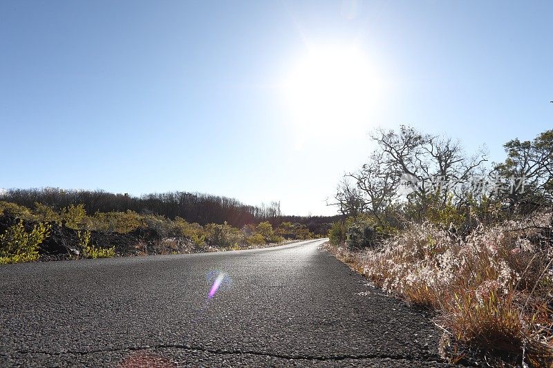 空旷的道路通向干旱景观上方的日出