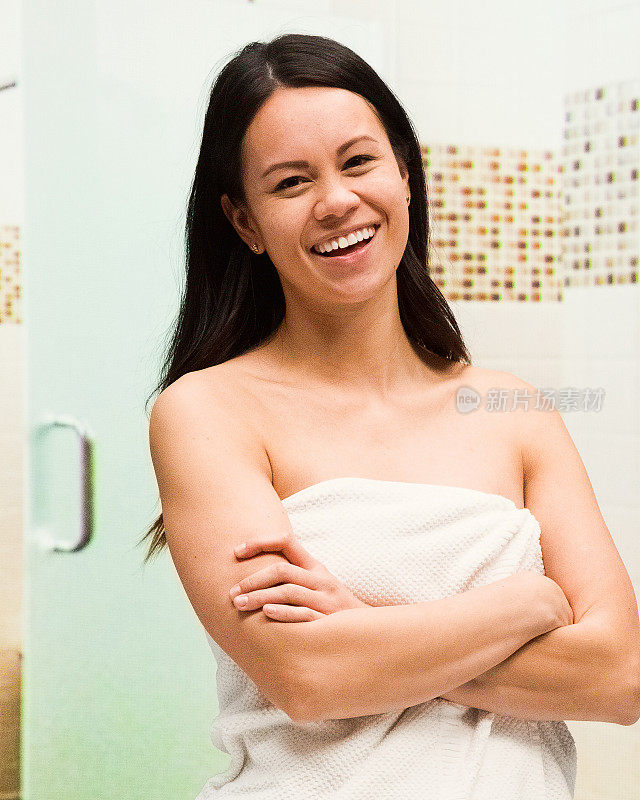 一个漂亮的女人拿着毛巾在健身房洗澡