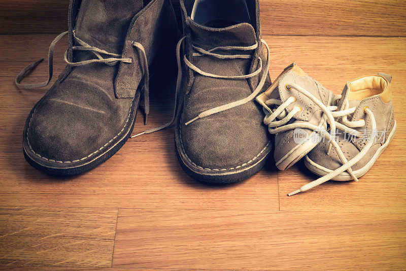 父亲的鞋子靠近孩子的鞋子的特写