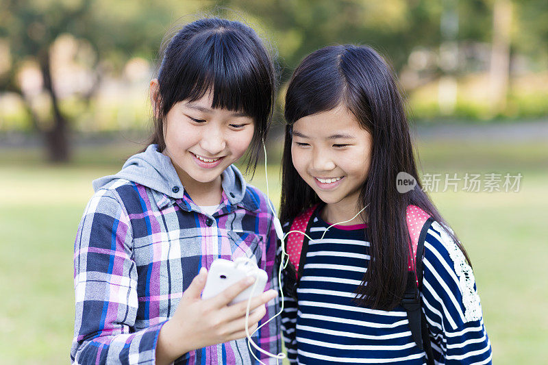 两个少女朋友在学校看智能手机