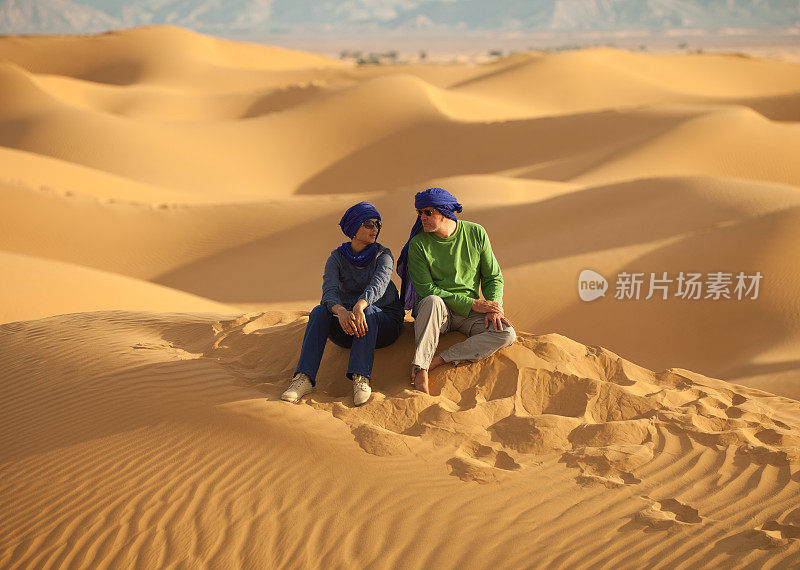一对夫妇在利比亚撒哈拉沙漠的沙丘上