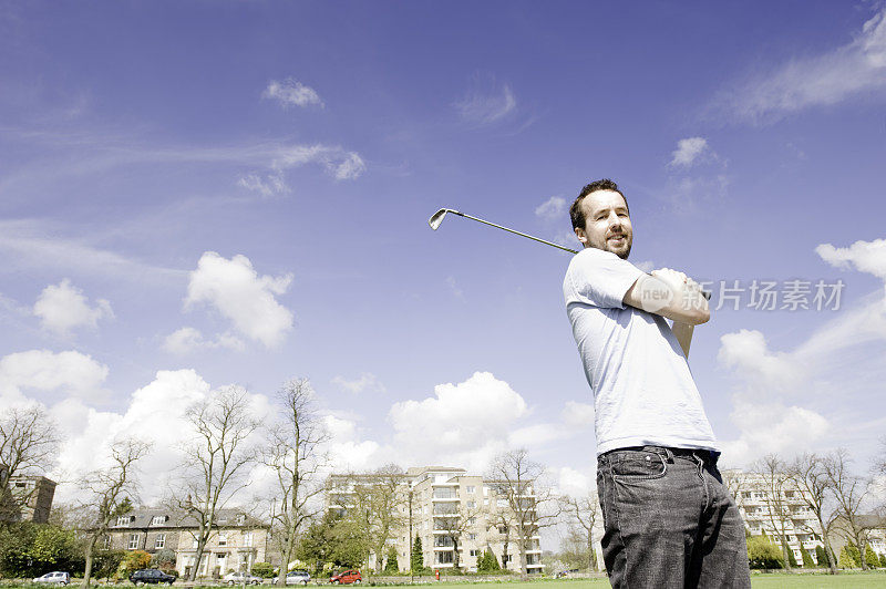男子在公园练习高尔夫挥杆