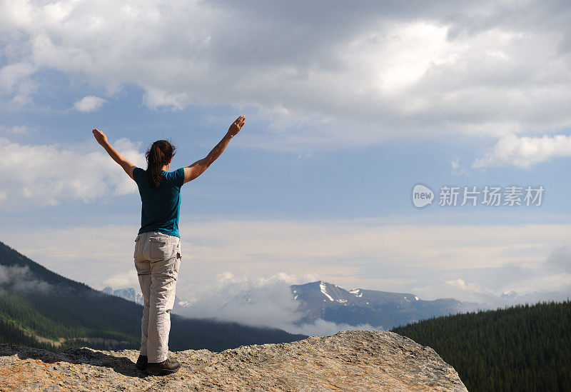 在空中举起双手俯瞰山景的女人