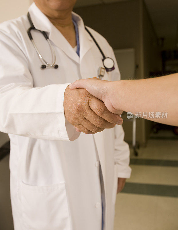 医生在和一位女病人握手。