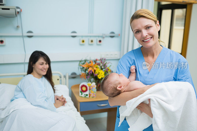 快乐的护士抱着新生婴儿
