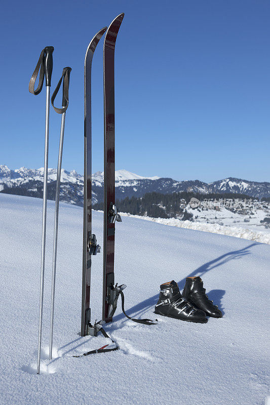 老式滑雪板、雪靴和雪杖都屹立在雪地里