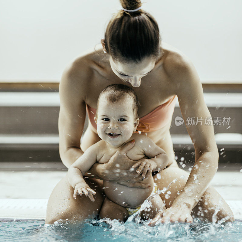 母亲和婴儿在泳池边