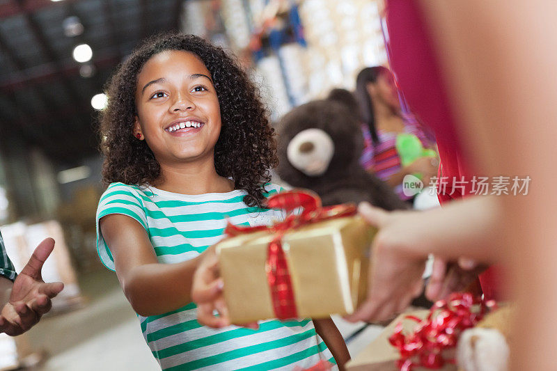 小女孩在玩具捐赠慈善活动中捐赠圣诞礼物