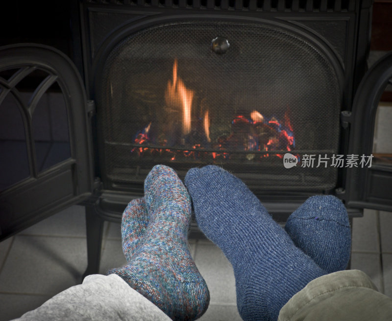 在壁炉前暖脚。