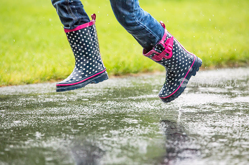 孩子在雨中跑过水坑