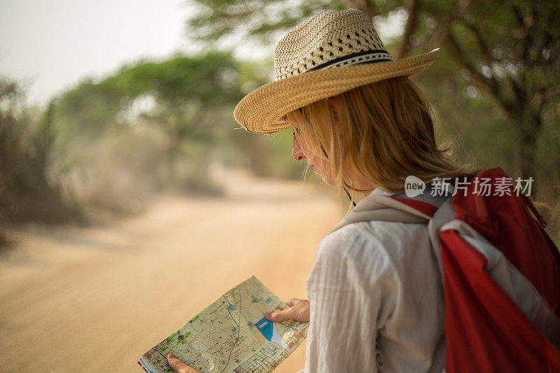 在沙漠中阅读地图的迷路旅行者