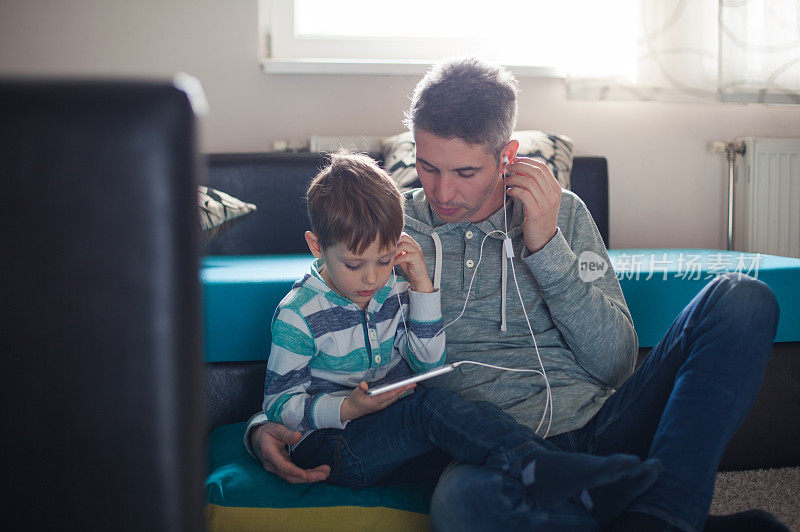 父亲和儿子在听音乐。