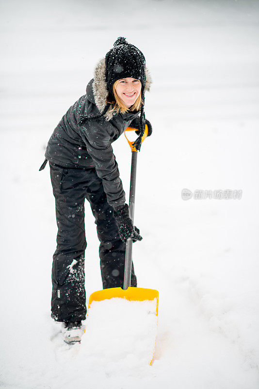 暴风雨后在她的车道上铲雪