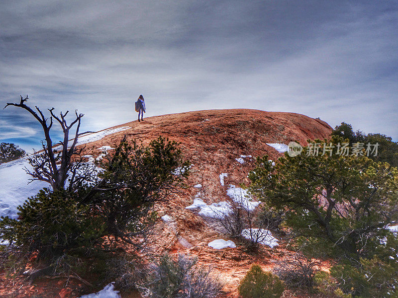 独自徒步者攀登弯曲山山顶，峡谷地，犹他州