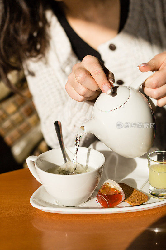 往杯子里倒茶的女人