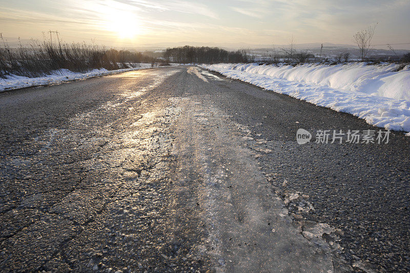 穿过乡村的结冰的柏油路