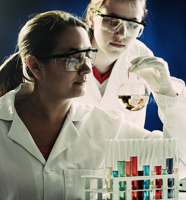 两位严肃的女科学家研究实验室烧瓶中的液体