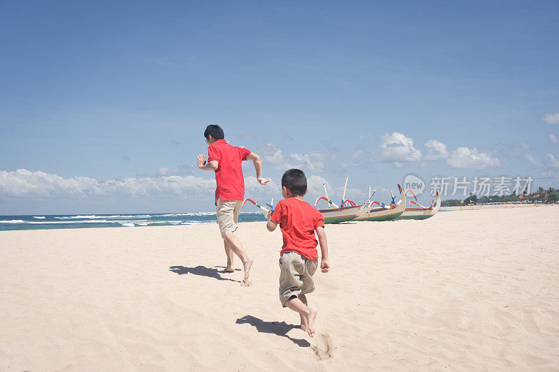 父亲和儿子在海滩上追逐
