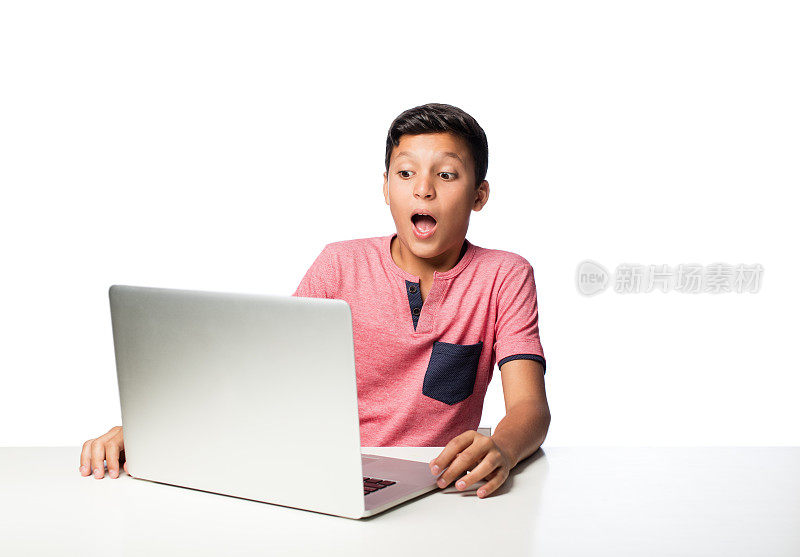 惊讶的少年看着笔记本电脑