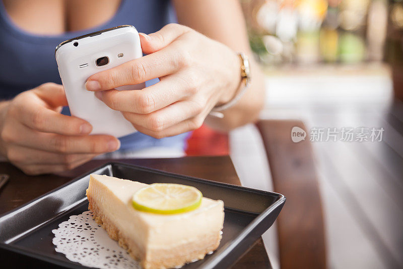 一个女人正在用手机拍食物