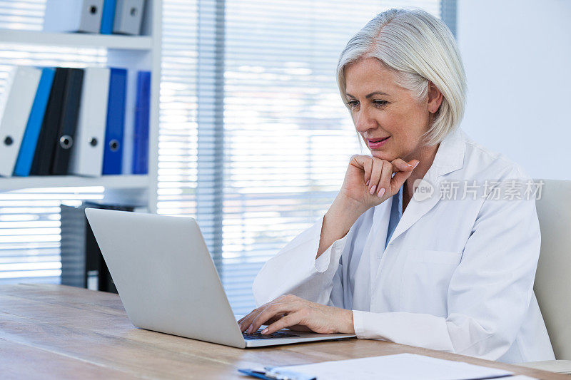 体贴的女医生在用笔记本电脑工作