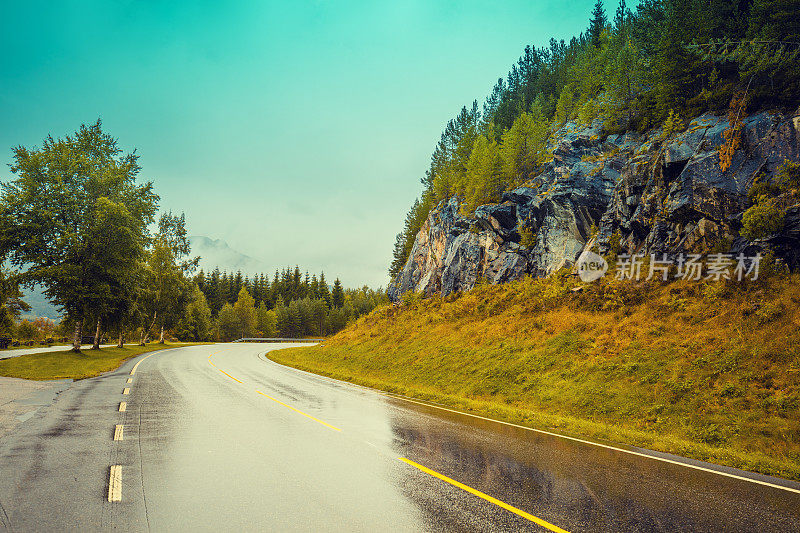 在山路上开车。山路与惊心动魄的暴风雨多云的天空。挪威美丽的大自然。