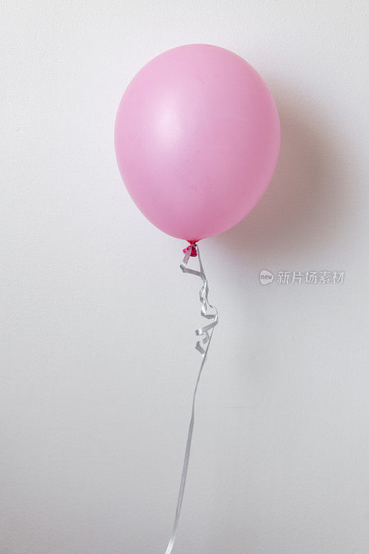 粉红色气球漂浮在空中，白色背景与拷贝空间
