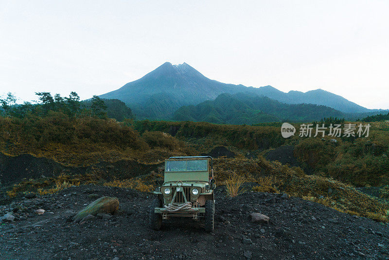 在默拉皮火山的背景上老式SUV的风景