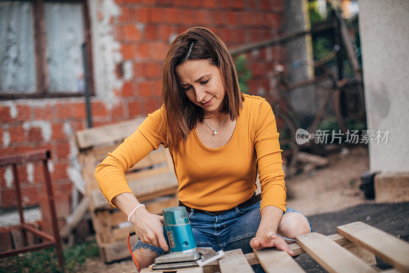 一个女人在工地上刮木板