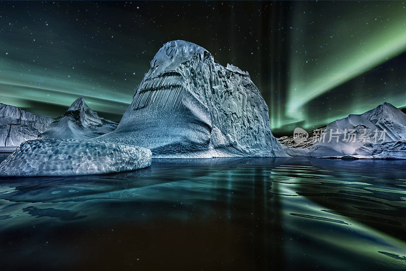 冰山漂浮在格陵兰峡湾的夜晚与绿色北极光