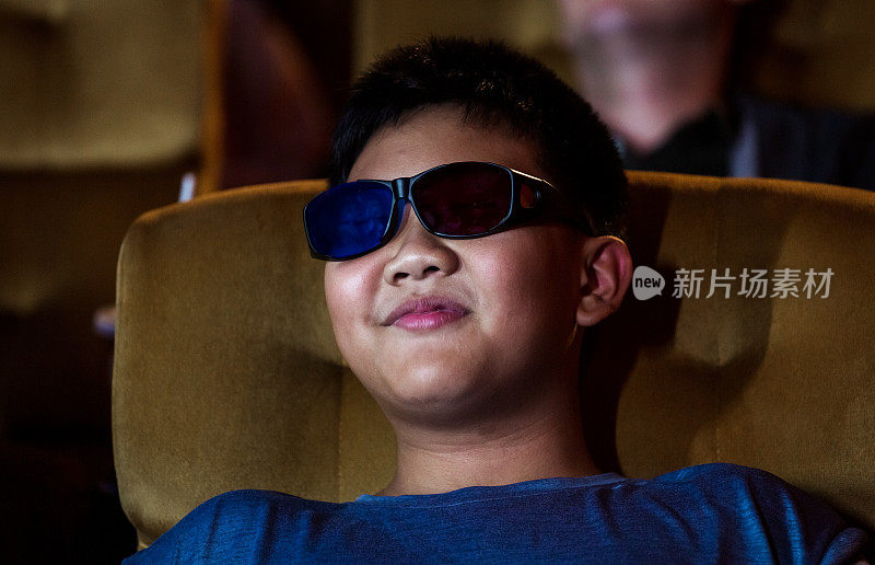 男孩坐在电影院看3D电影