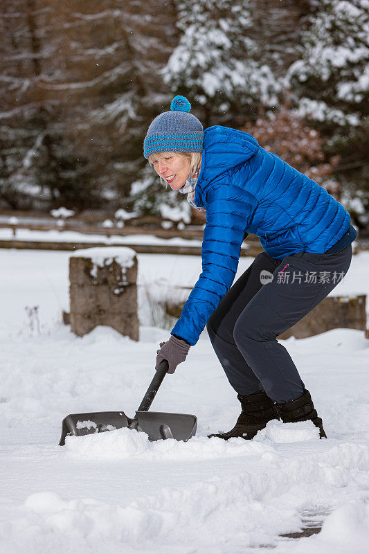 老妇人拿着雪铲