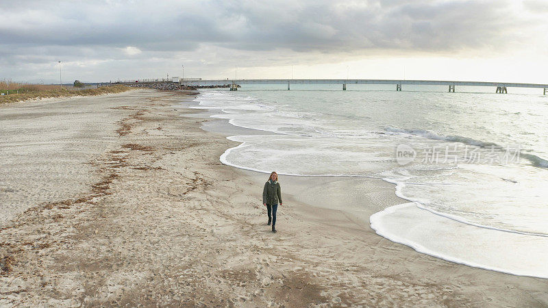 一个孤独的女人在海边漫步