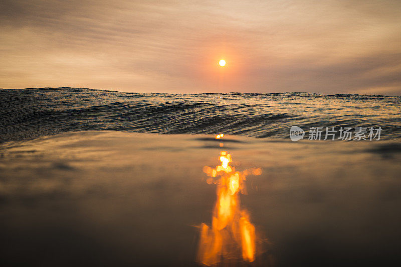 海浪和橙色阳光在海洋中的反射