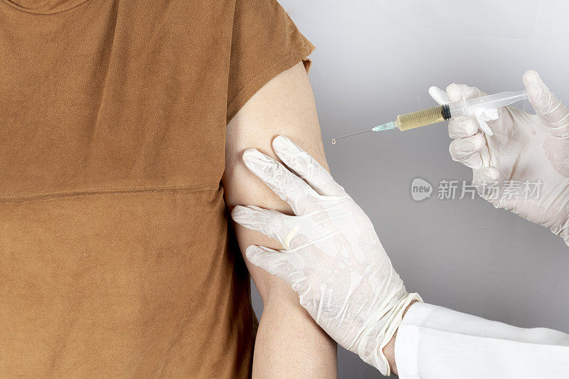 疫苗或流感注射针。医生用病人的手臂工作。医生或护士用注射器注射疫苗及免疫病毒、流感或人乳头瘤病毒。