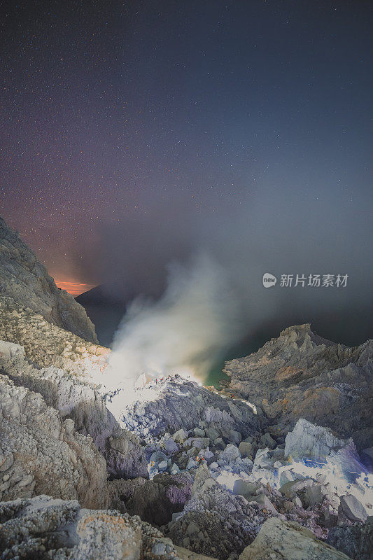 硫磺湖和冒烟的矿山山早上在卡瓦伊真火山印度尼西亚东爪哇与银河夜空的背景