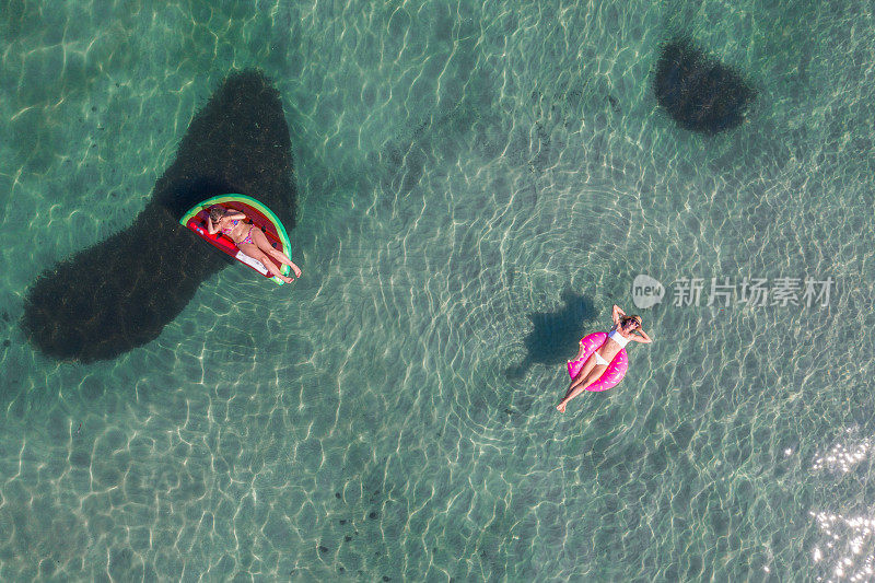 女性漂浮在湖面上的充气筏的鸟瞰图