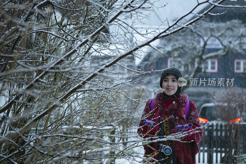 亚洲穆斯林游客在哈尔斯塔特享受冬天的雪