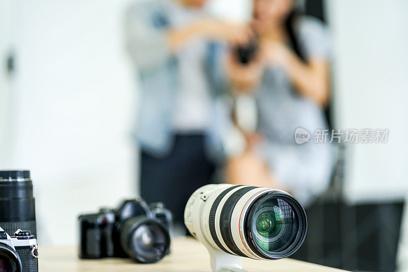 摄影幕后:摄影师用数码相机在创意家居工作室拍摄女模特的照片